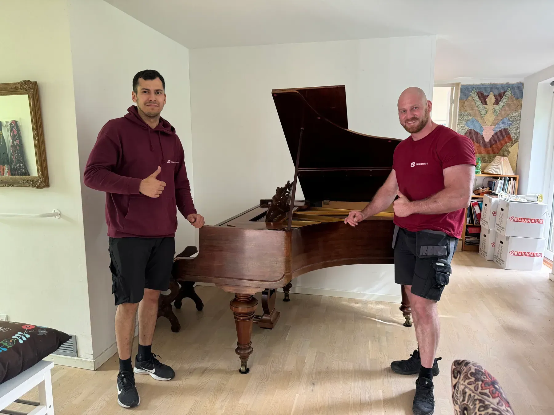 Two movers by a grand piano after a piano move