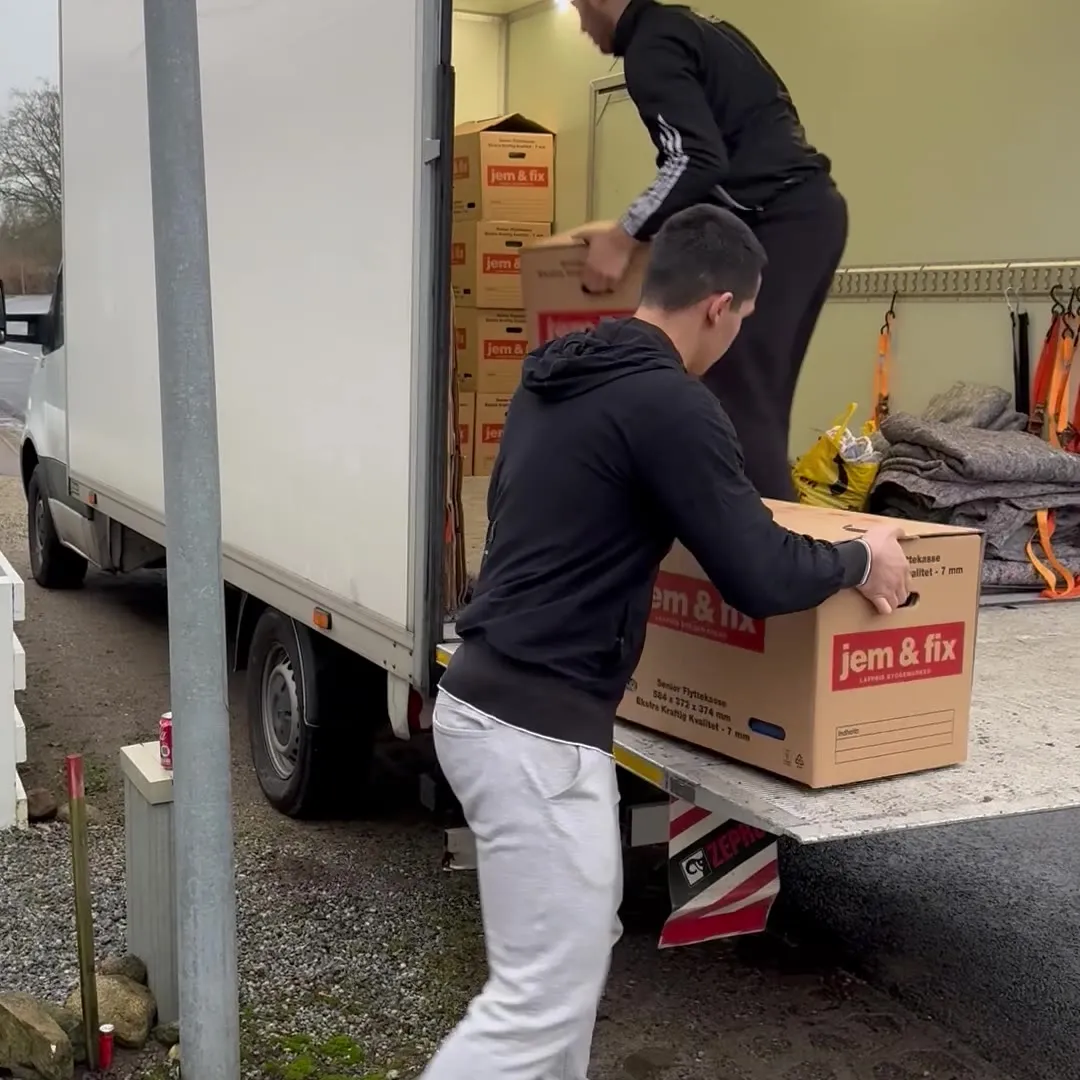 Movers loading packed moving boxes into the van